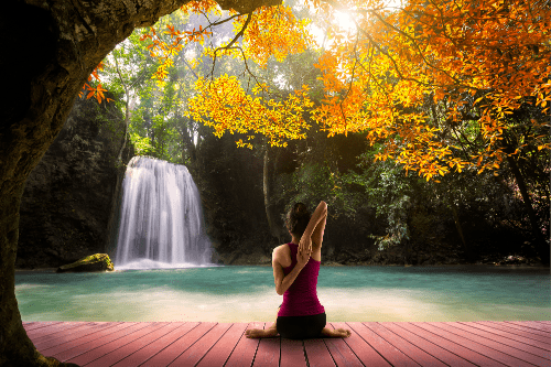 Faire du yoga face a une cascade d'eau