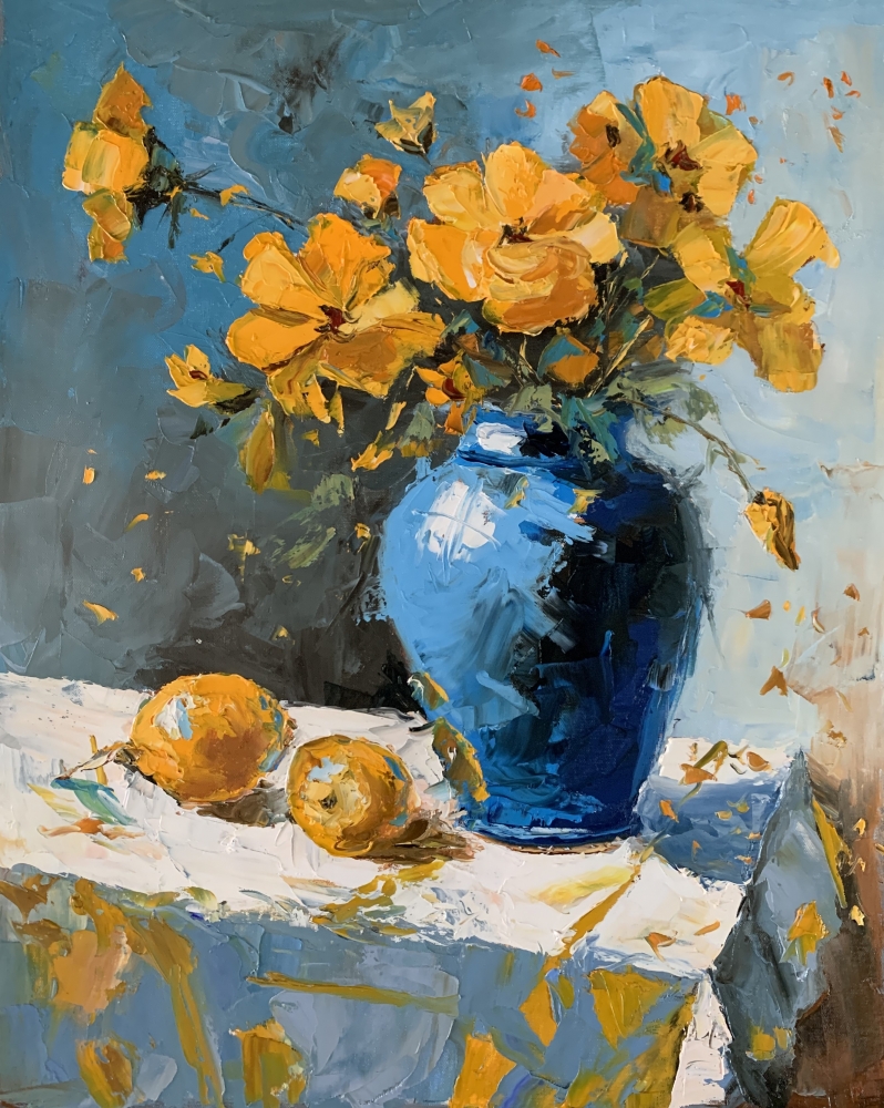 Yellow wild flowers in a blue vase.