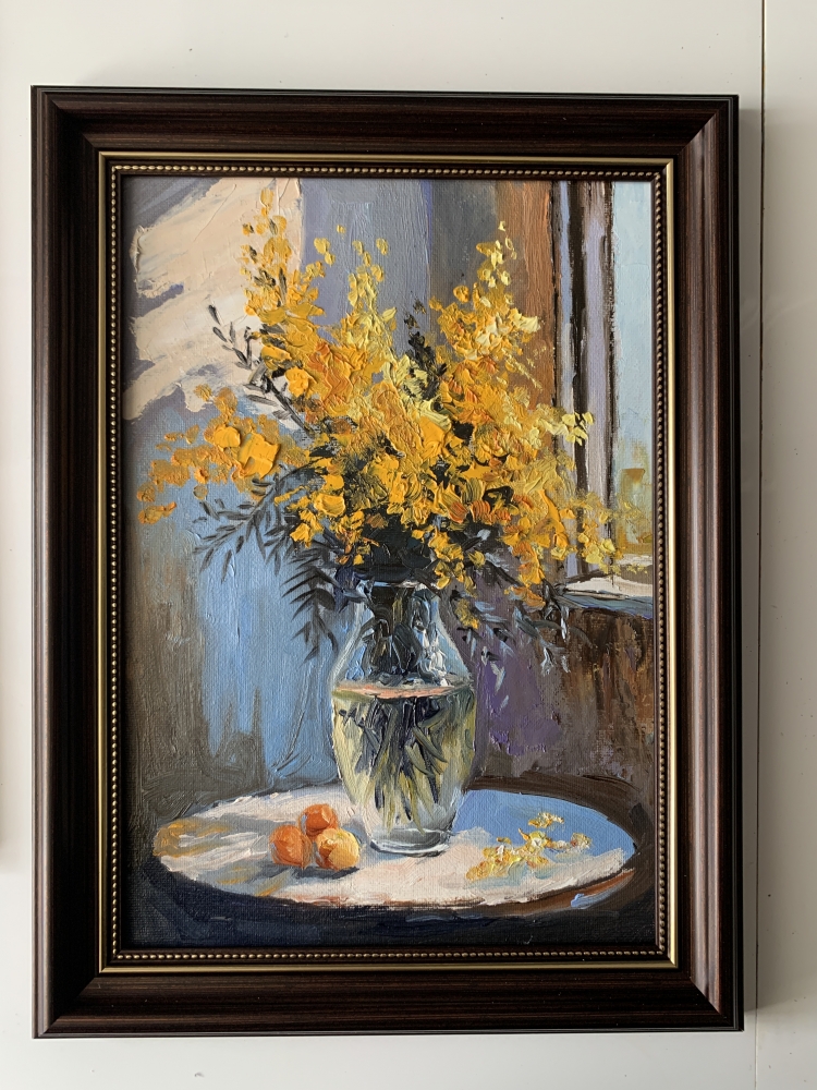 Bouquet of mimosa in a transparent vase by the window. Framed