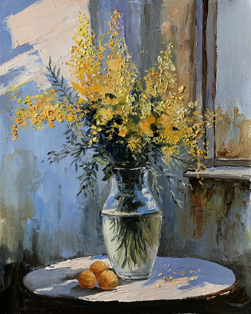 Bouquet of mimosa in a transparent vase by the window.