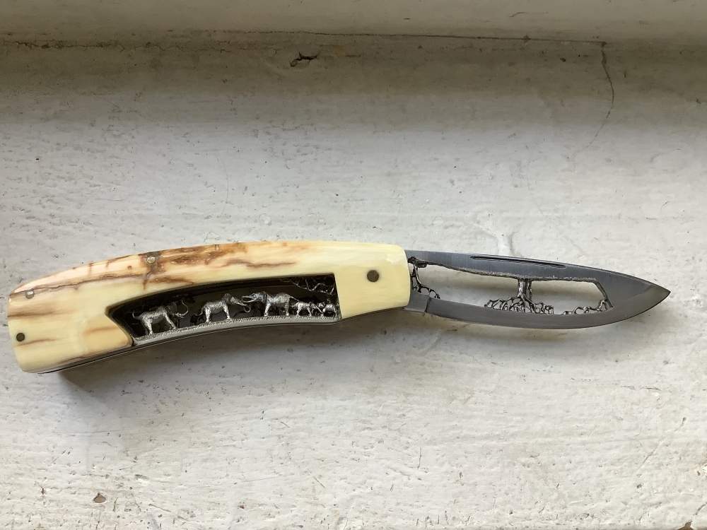 Charles m roulin it has a 3 inch blade and it’s 7 inches total it’s ivory with handmade art engraved elephants and trees and forest it took him over a year to make he’s top 5 craftsman 