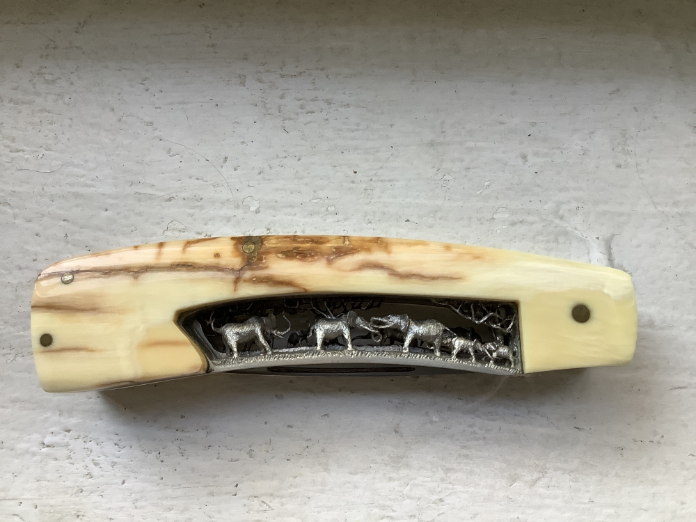 Charles m roulin it has a 3 inch blade and it’s 7 inches total it’s ivory with handmade art engraved elephants and trees and forest it took him over a year to make he’s top 5 craftsman 