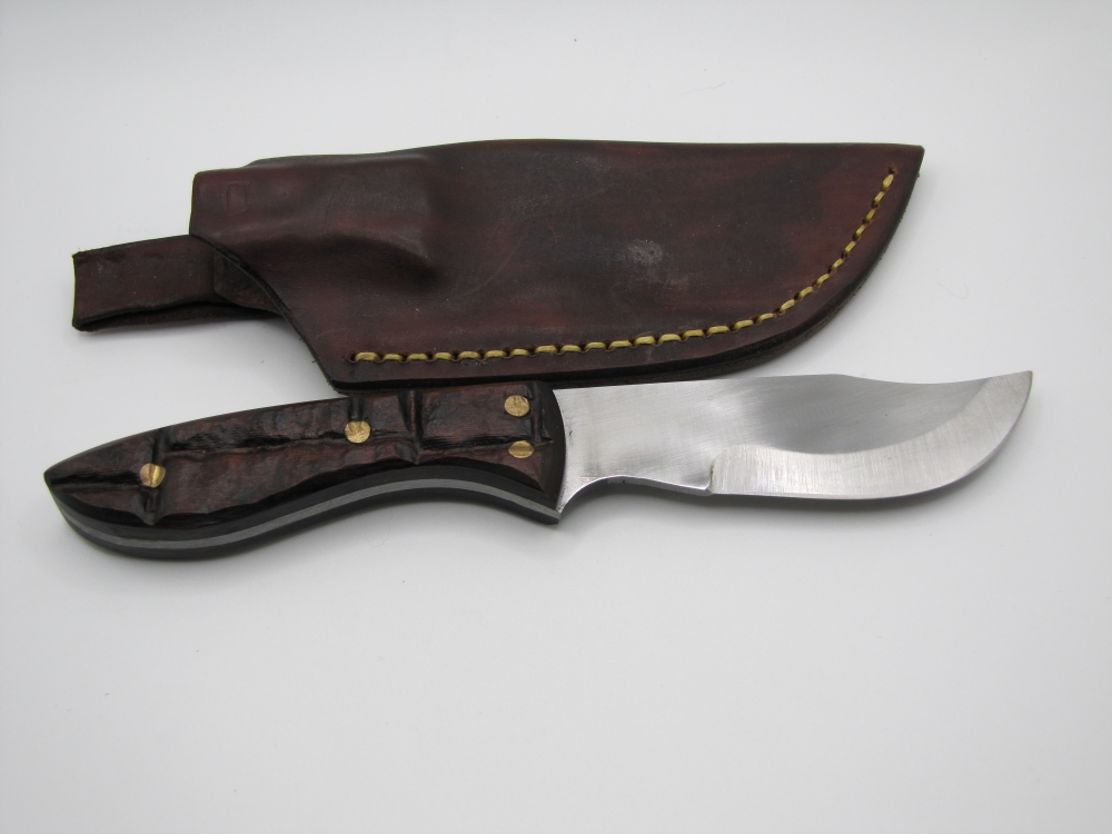 1095 high carbon steel clip point skinning knife with a brick like walnut dymalux handle