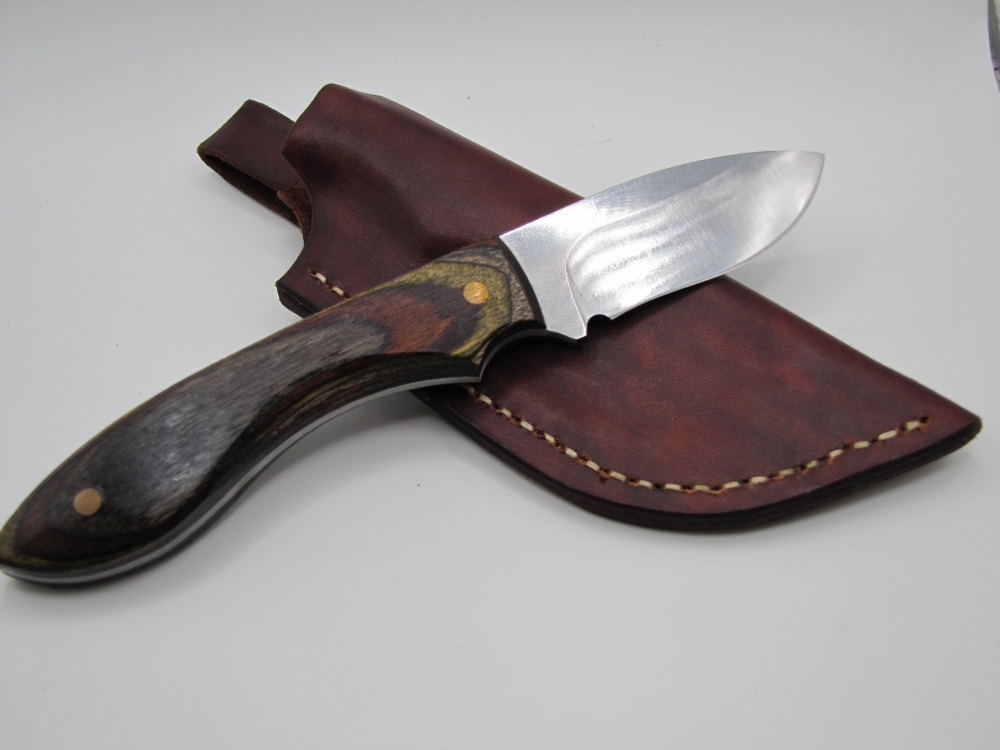 1095 high carbon steel drop point skinner with black olive walnut camo dymalux handle