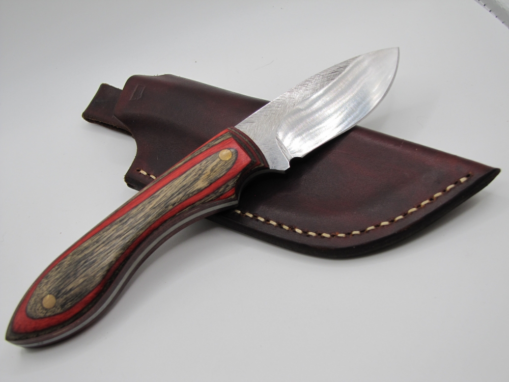 1095 high carbon steel drop point skinner with red and black dymalux handle