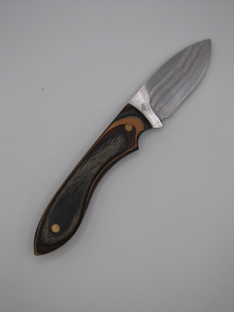 1095 high carbon steel drop point skinner with a black walnut an natural camo dymalux handle