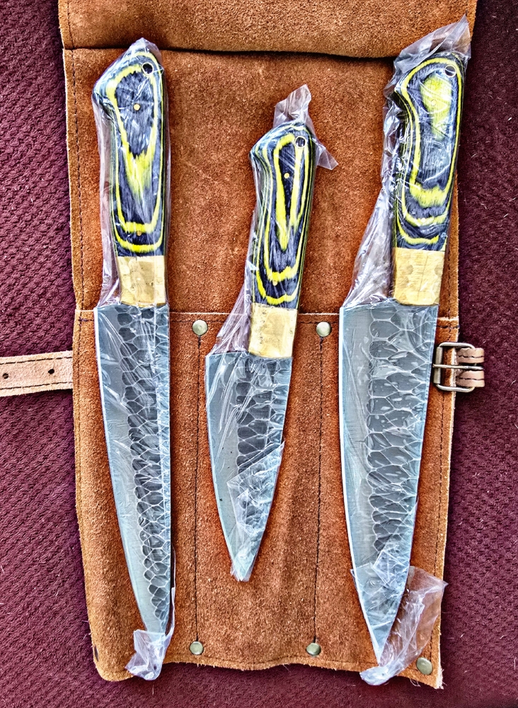 Triple set of kitchen knives. Swede leather carry case. Pakka wood handle. Dishwasher safe.  Colors available RED, BLUE, YELLOW. 