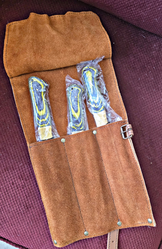 Triple set of kitchen knives. Swede leather carry case. Pakka wood handle. Dishwasher safe.  Colors available RED, BLUE, YELLOW. 