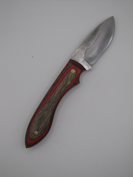 1095 high carbon steel drop point skinner with red and black dymalux handle