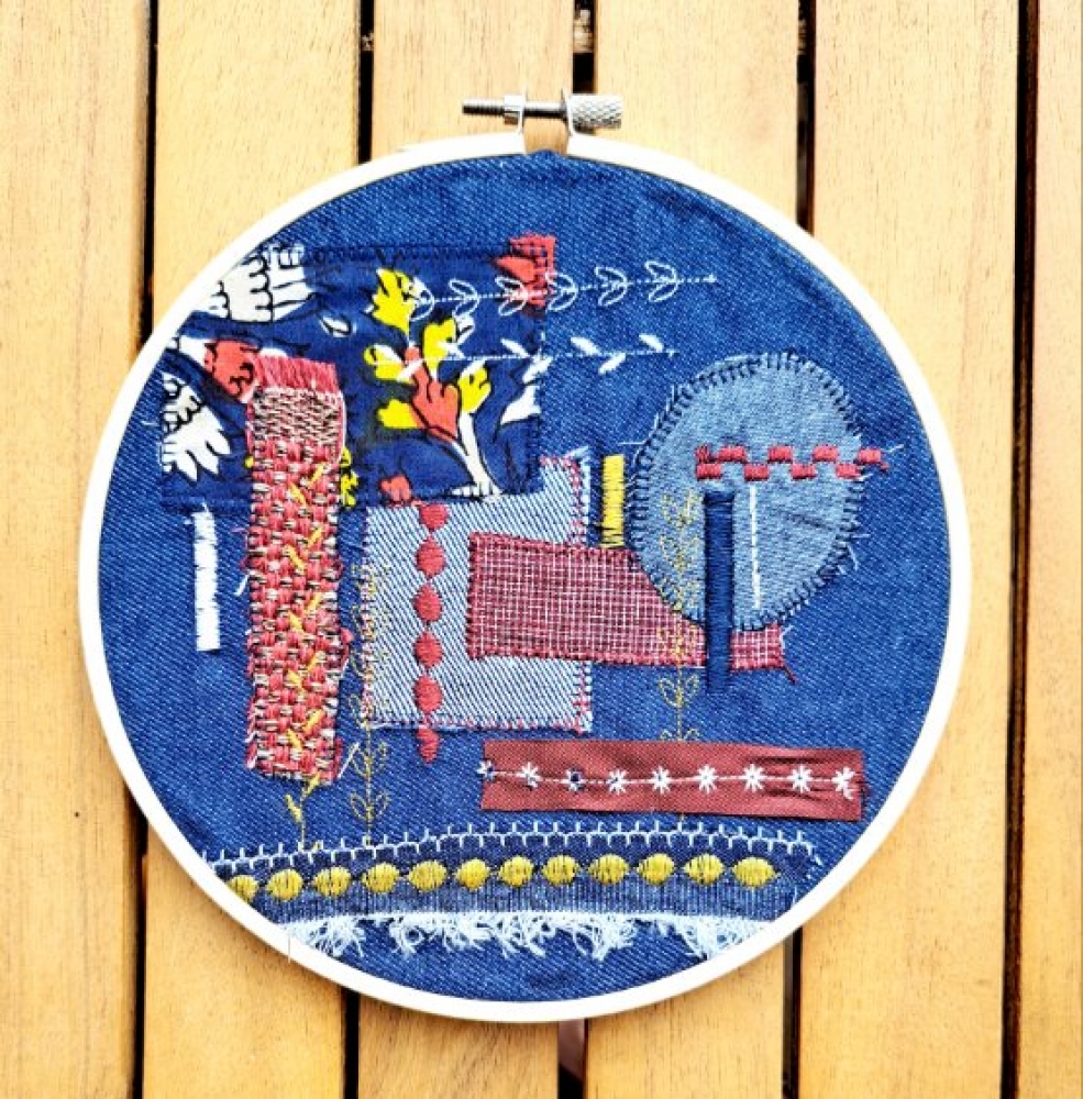 Broderie upcyclée – Création unique en tissus et fils de récupération, présentée dans un tambour