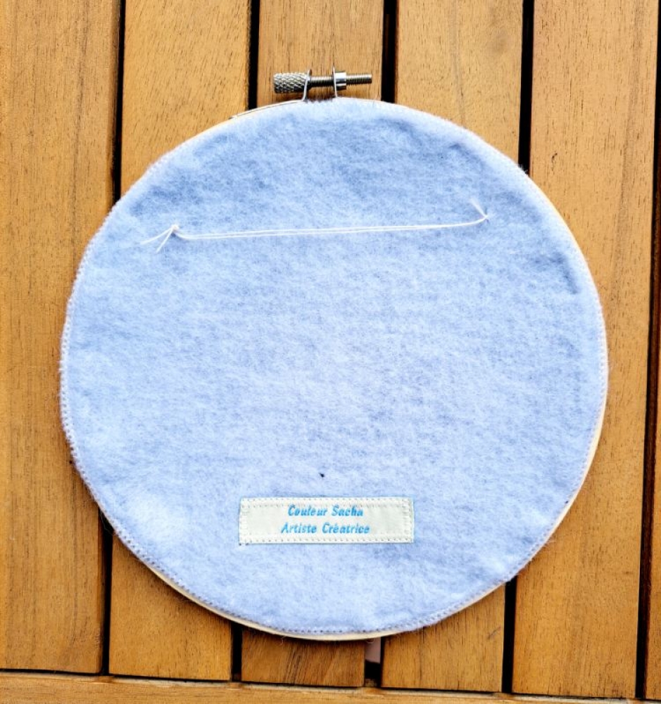 Broderie upcyclée – Création unique en tissus et fils de récupération, présentée dans un tambour