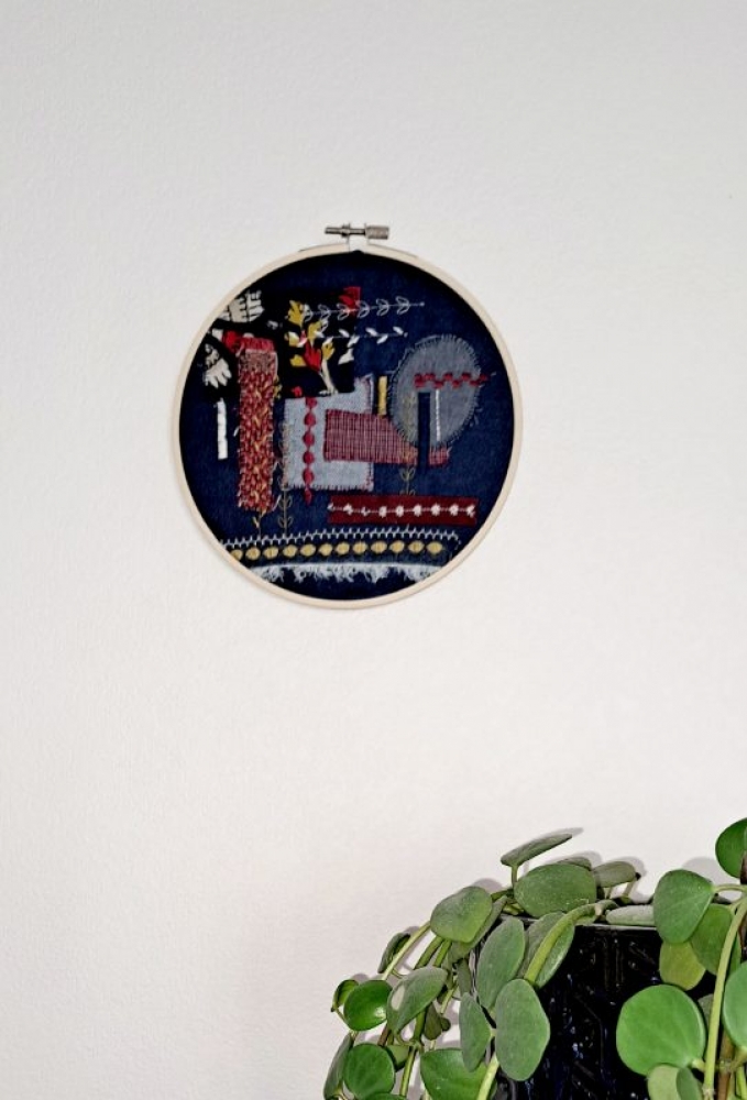 Broderie upcyclée – Création unique en tissus et fils de récupération, présentée dans un tambour