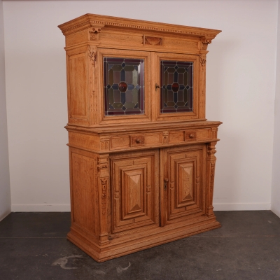 Meuble 2 corps en bois sculpté, portes parties hautes garnies de vitraux en verre coloré.