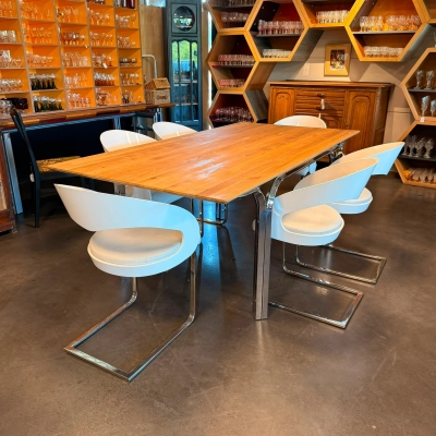 Table de salle à manger, piétement en métal chromé, plateau en bois huilé.