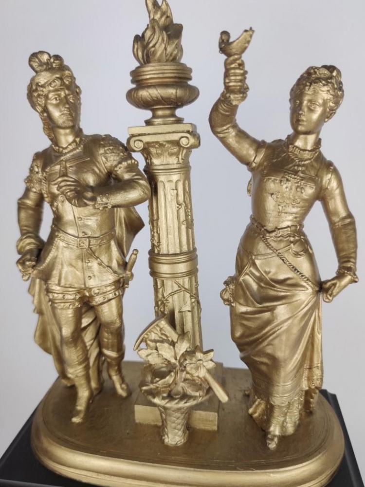 Reloj de sobremesa, mármol negro y bronce dorado, con figuras
