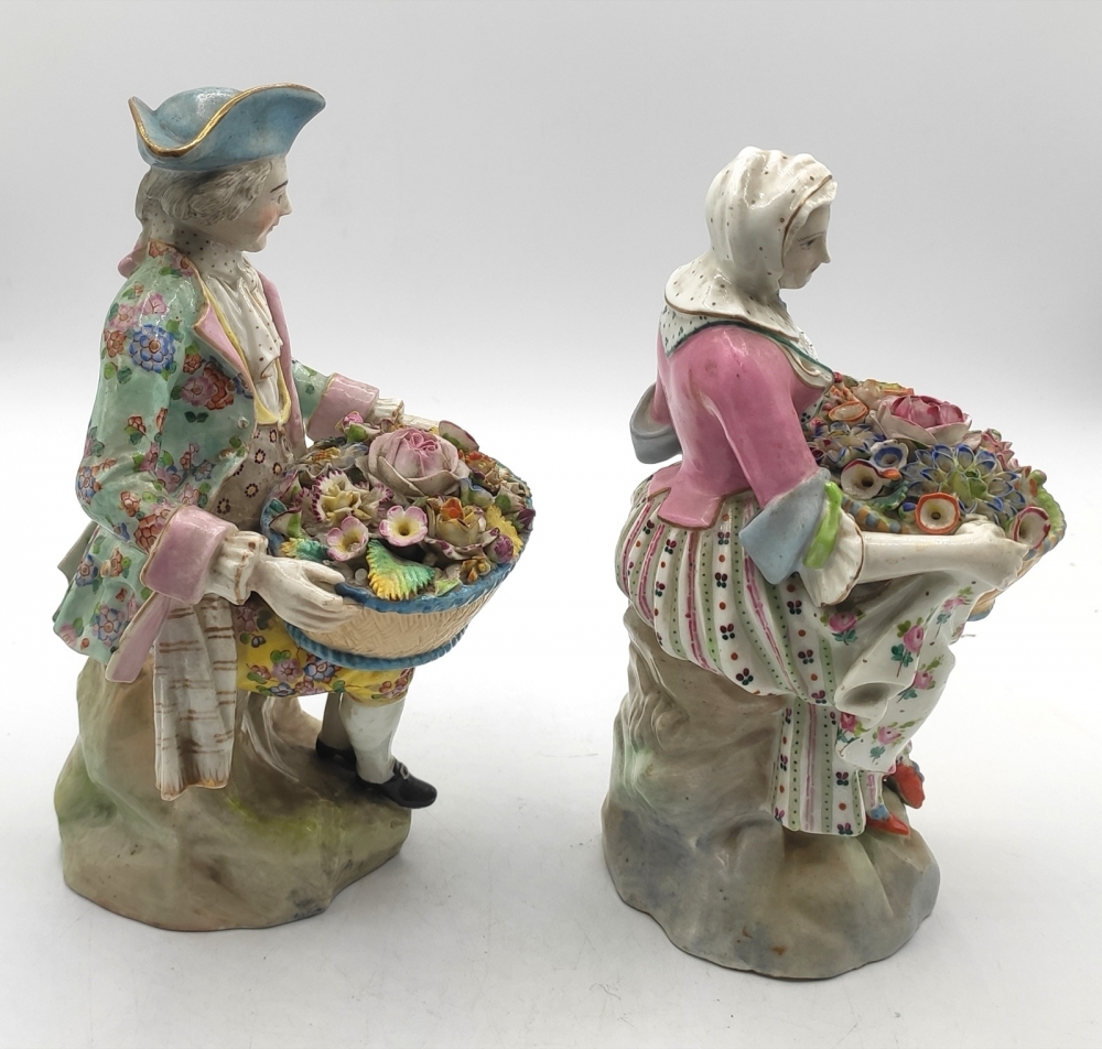 Pareja de figuras de jardineros con cestos de flores en porcelana policromada, con marca de espadas cruzadas