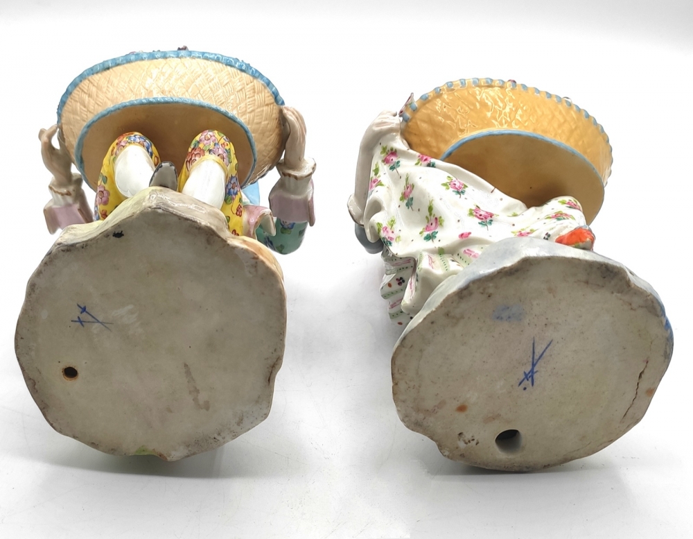Pareja de figuras de jardineros con cestos de flores en porcelana policromada, con marca de espadas cruzadas