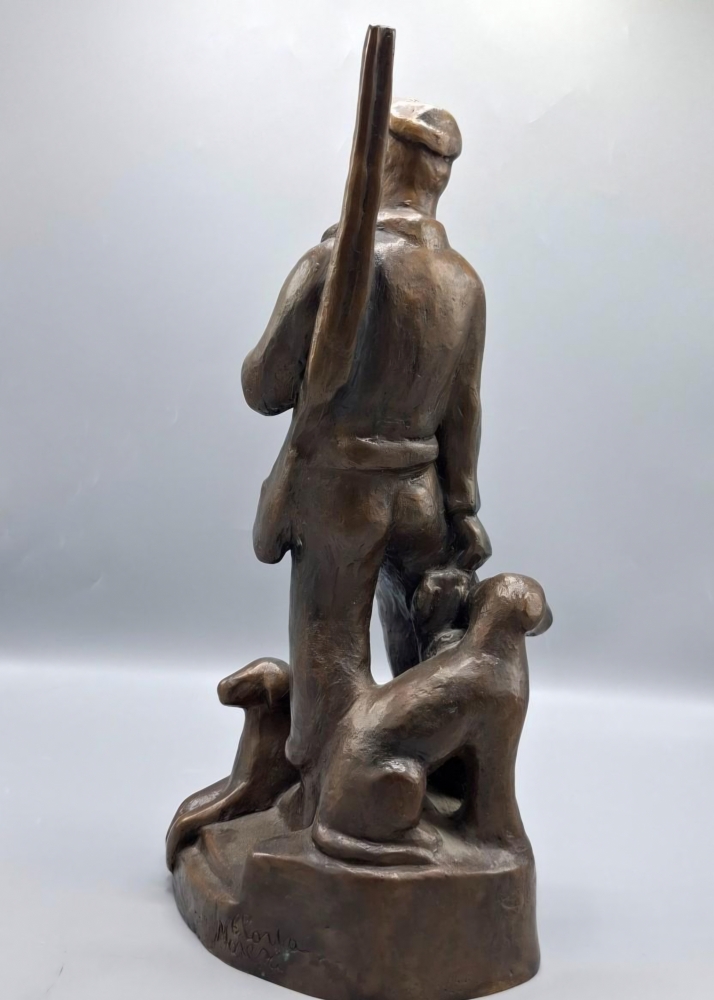 Escultura en bronce de cazador con perros, firmada Gloria Morera