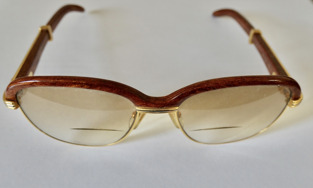 Gafas Cartier modelo Malmaison en madera de palisandro y metal dorado, con estuche y tarjeta de garantía, Francia, finales del siglo XX