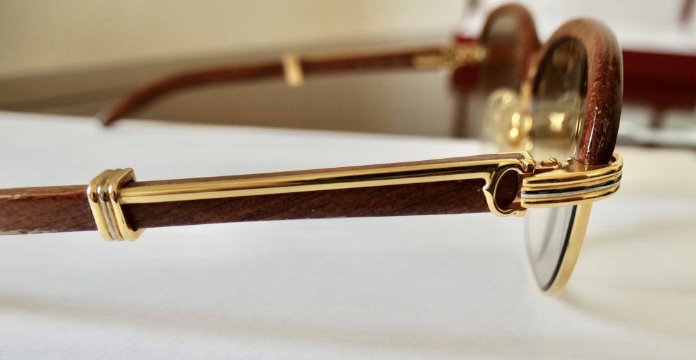 Gafas Cartier modelo Malmaison en madera de palisandro y metal dorado, con estuche y tarjeta de garantía, Francia, finales del siglo XX