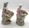 Pareja de figuras de jardineros con cestos de flores en porcelana policromada, con marca de espadas cruzadas