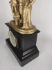 Reloj de sobremesa, mármol negro y bronce dorado, con figuras