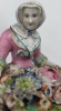 Pareja de figuras de jardineros con cestos de flores en porcelana policromada, con marca de espadas cruzadas
