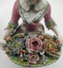 Pareja de figuras de jardineros con cestos de flores en porcelana policromada, con marca de espadas cruzadas
