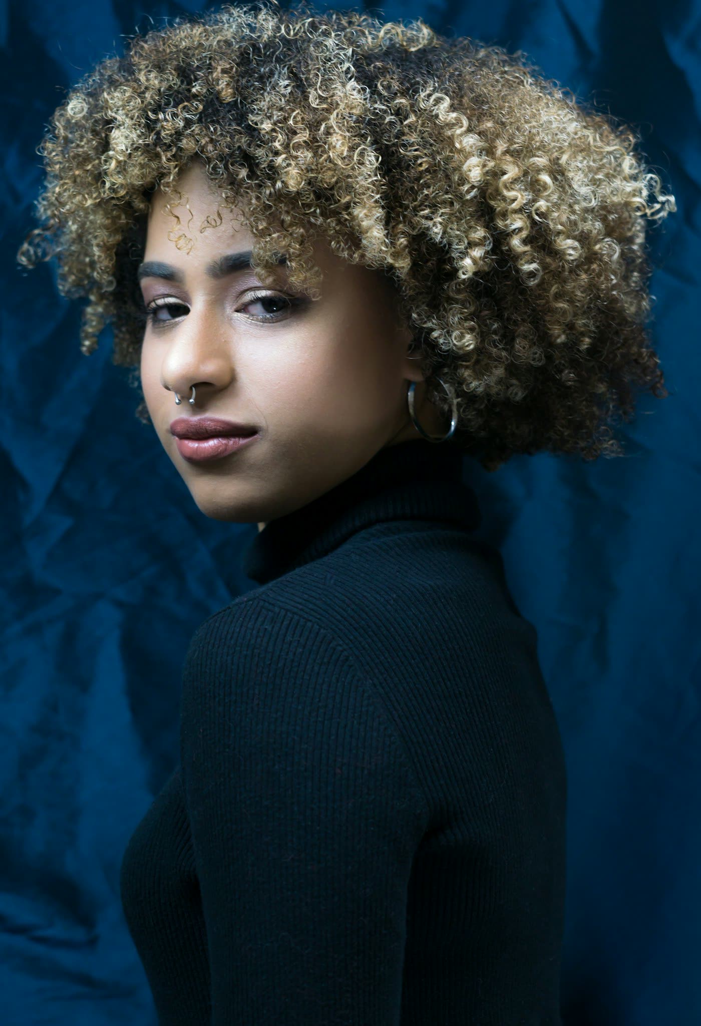 Portrait aux boucles blondes sur fond bleu