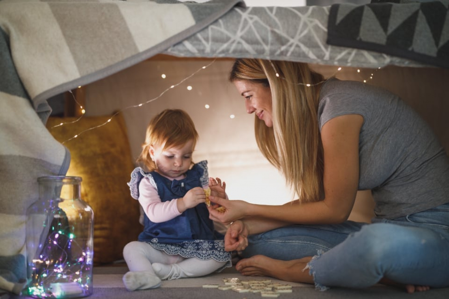 A family playing on the floor at home.