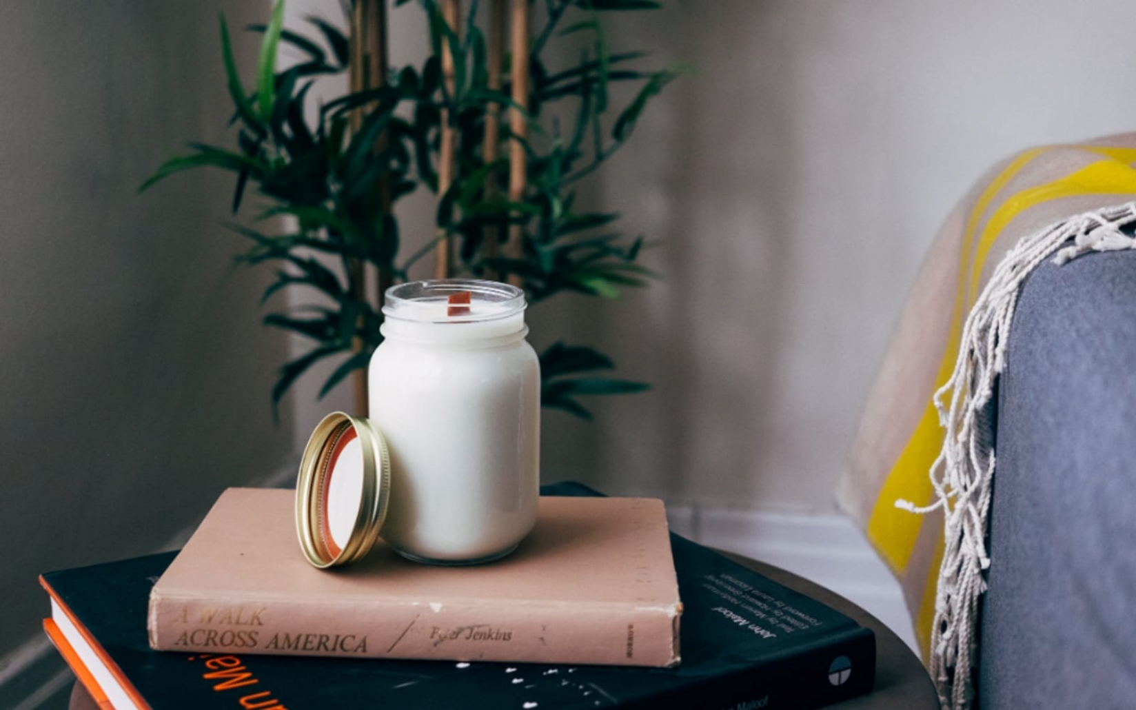 A hand-poured candle on a stack of books.