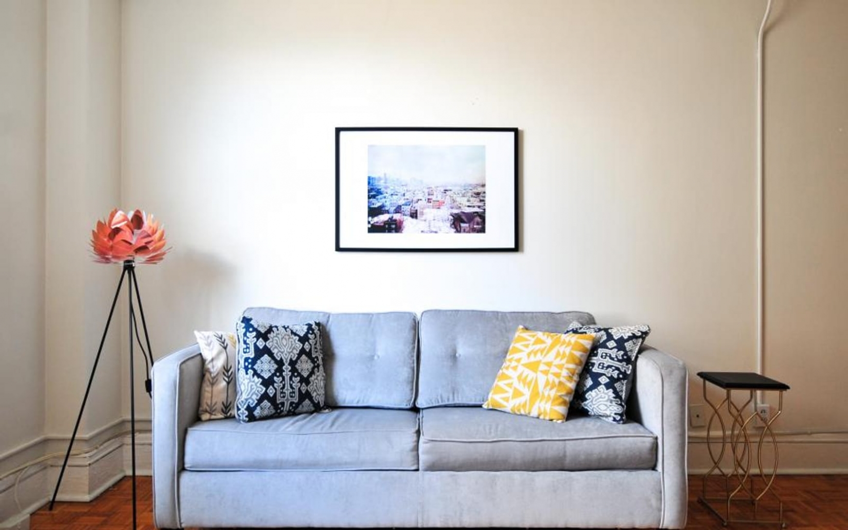 A small living room with a grey sofa.