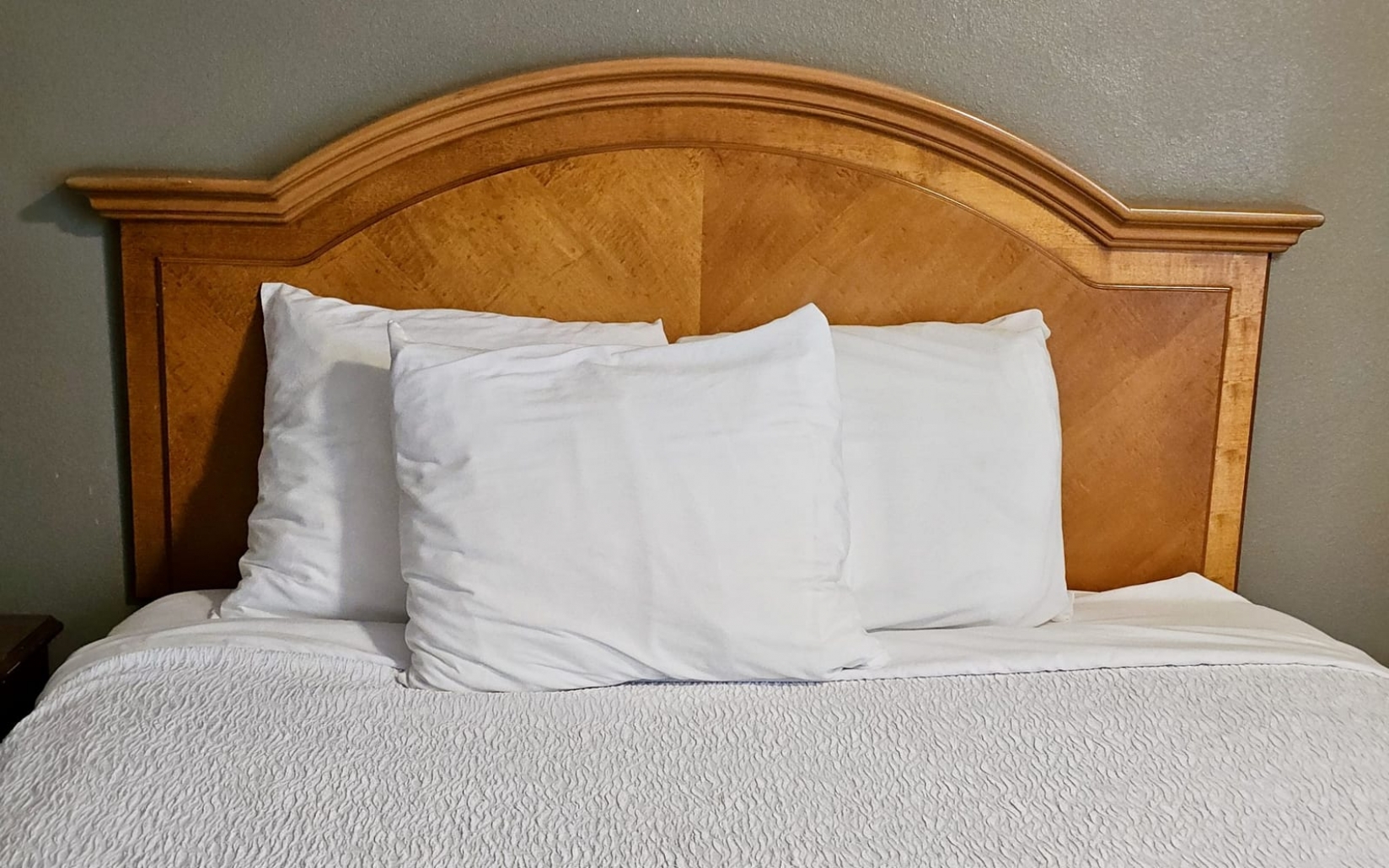 Fresh white bedding on a wooden bed.